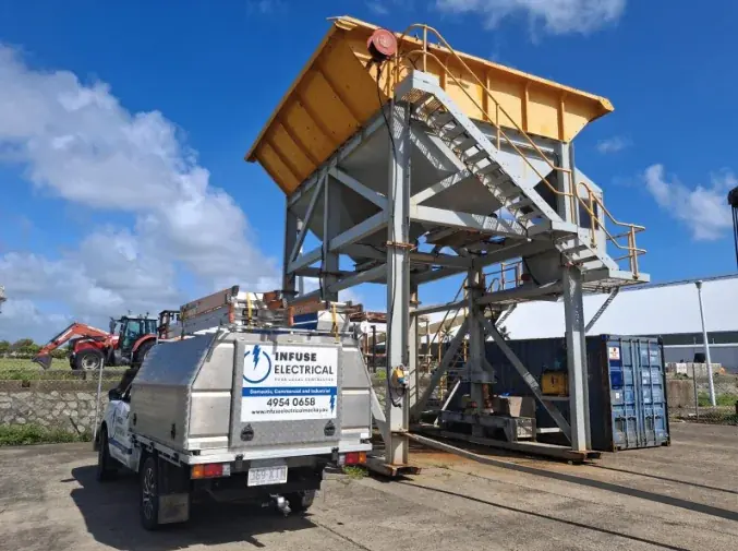 The Infuse Electrical service ute parked beside a steel hopper at a Mackay worksite