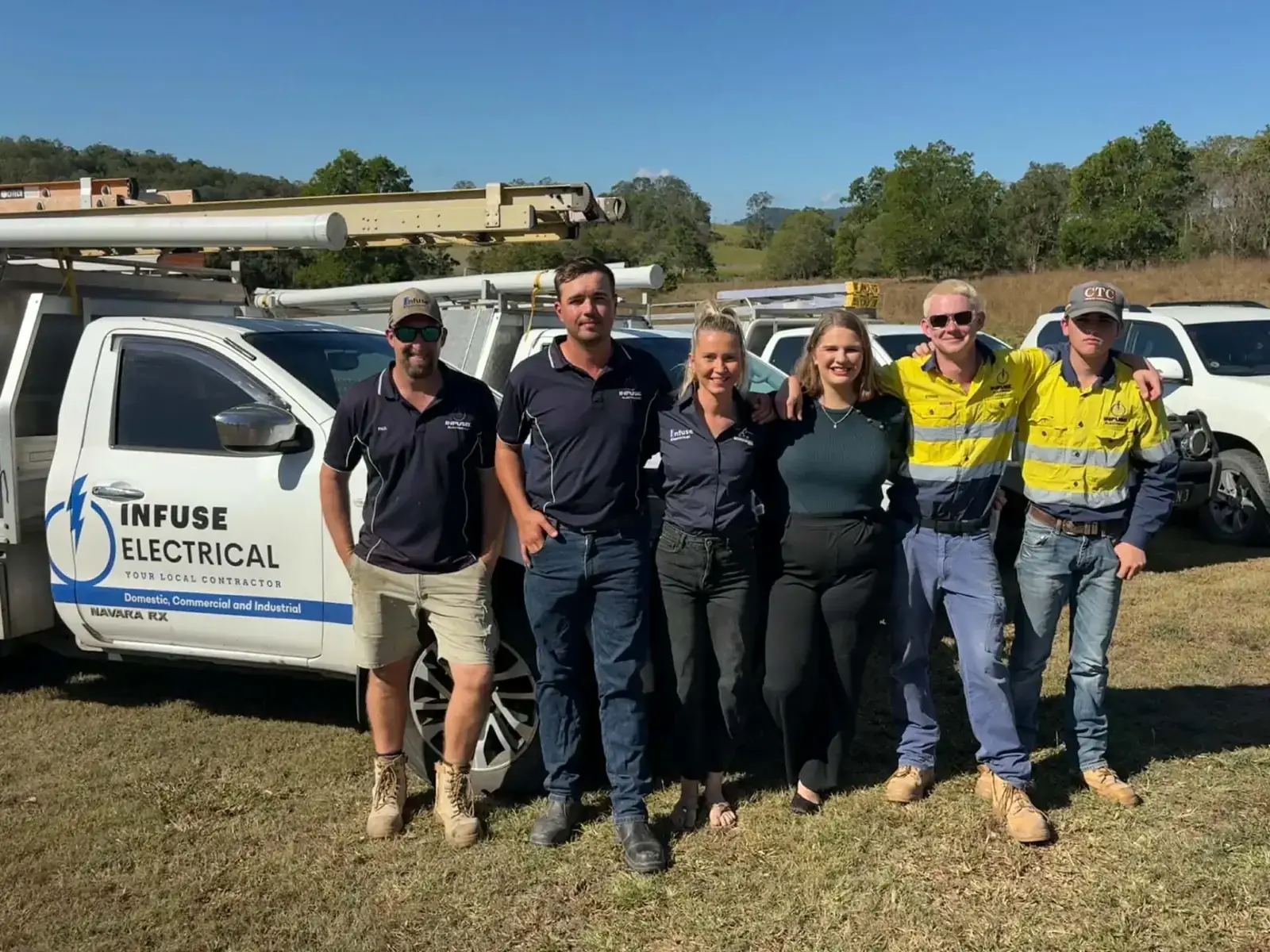 The Infuse Electrical team standing in front of their branded Mackay work utes